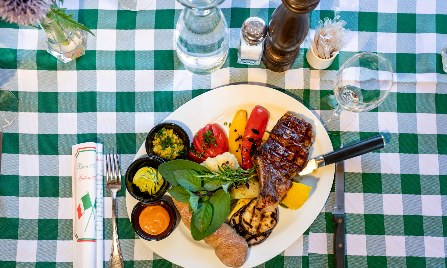 Ein liebevoll grilliertes Steak, mariniertes Gemüse und ein Stück warmes Brot